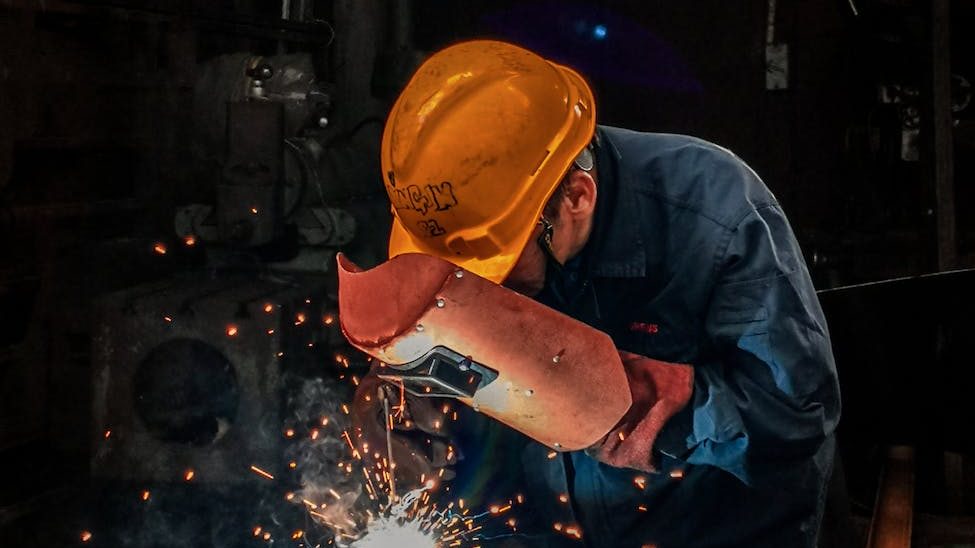 man welding on gray metal sheet